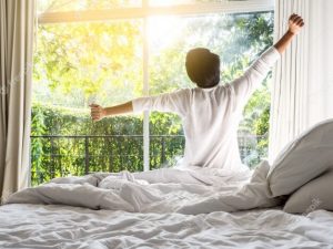 Hombre de espaldas estirandose despues de despertar - Lunes dia favorito